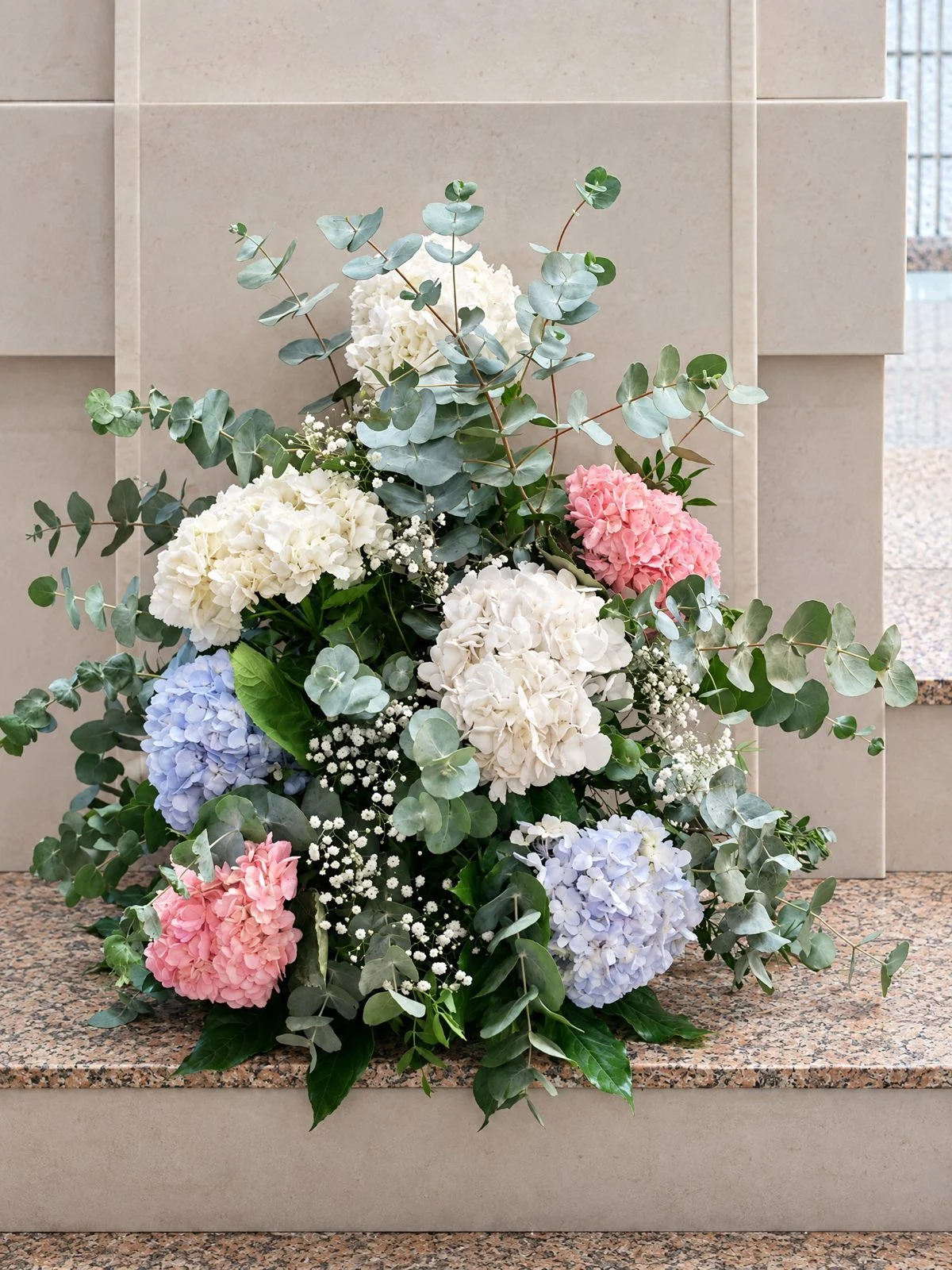 Arrangement of pink, blue and white hydrangeas by the altar