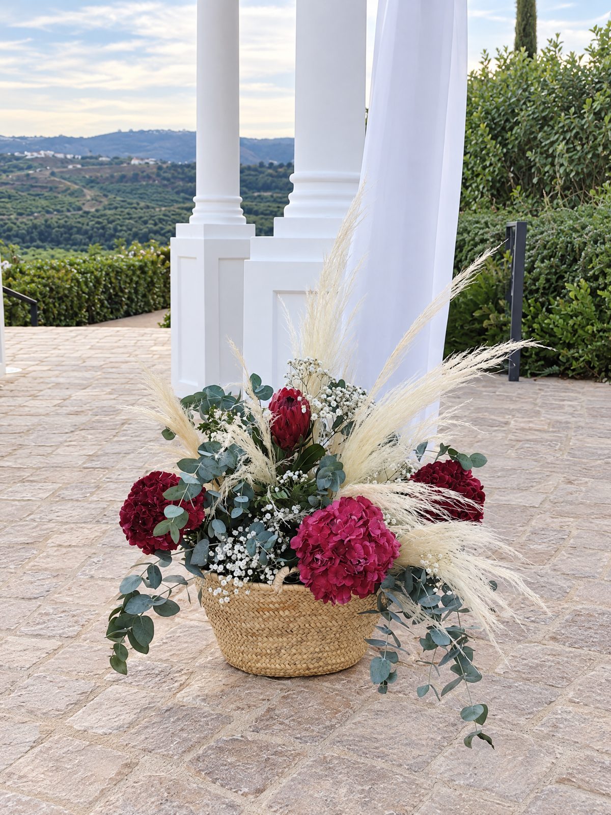 Basket of red hydrangeas and roses, pampas grass and eucalyptus