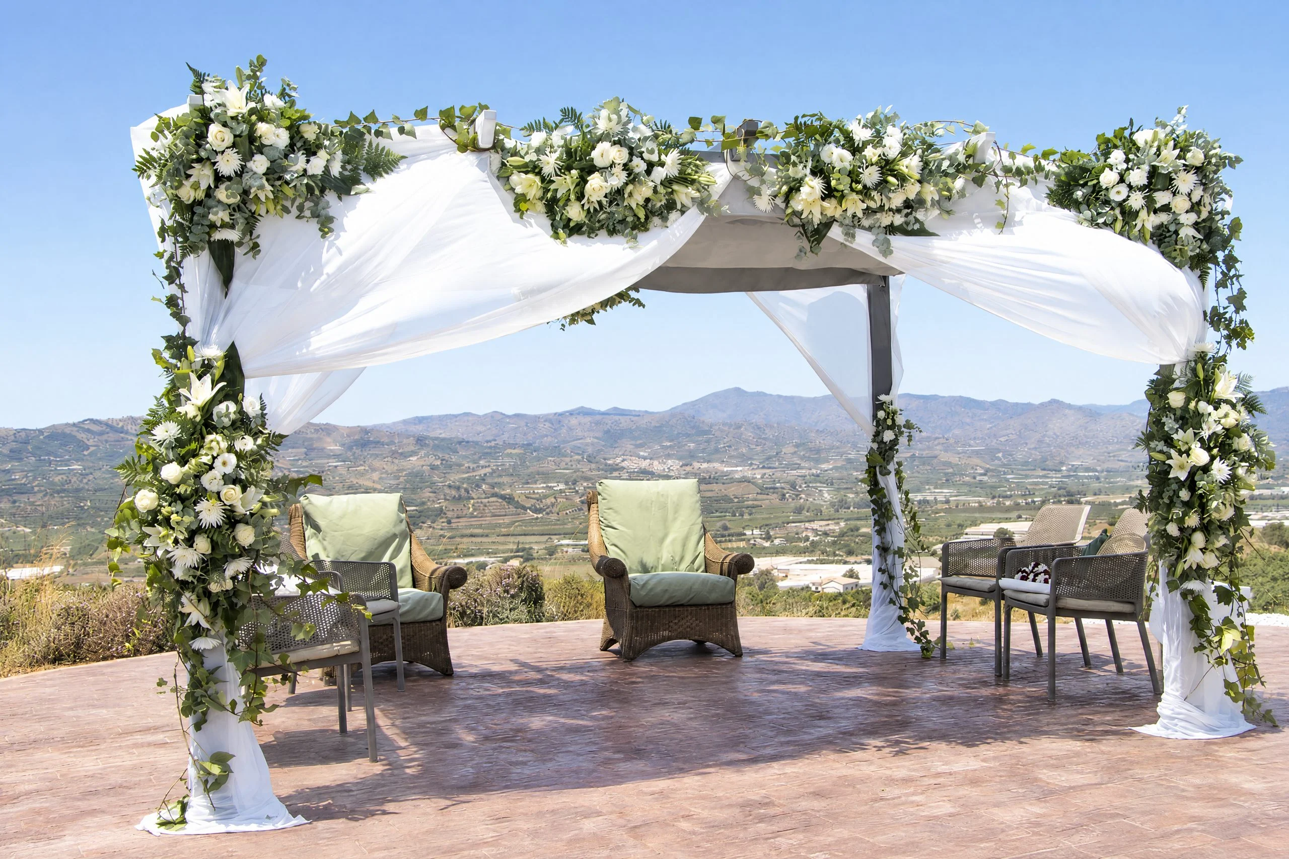 Wedding flowers: a pergola dressed in white flowers at a finca in Vélez-Málaga, with the Axarquía behind