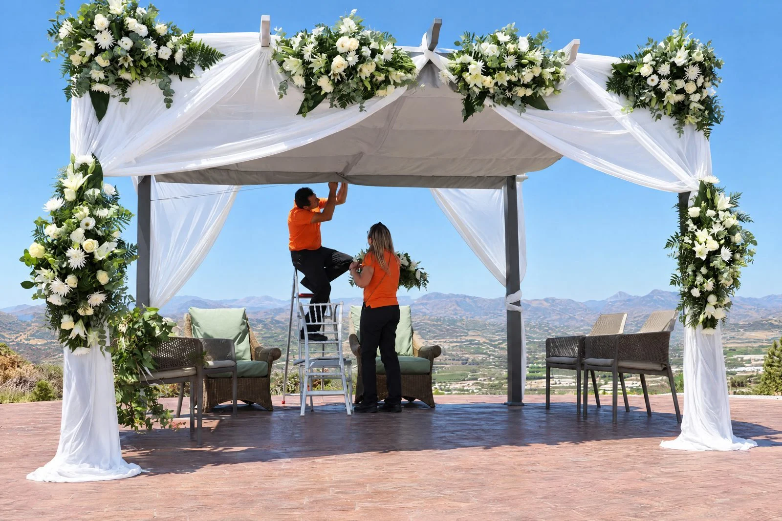 Two Florymar florists setting up a white-flower pergola at a finca in Vélez-Málaga